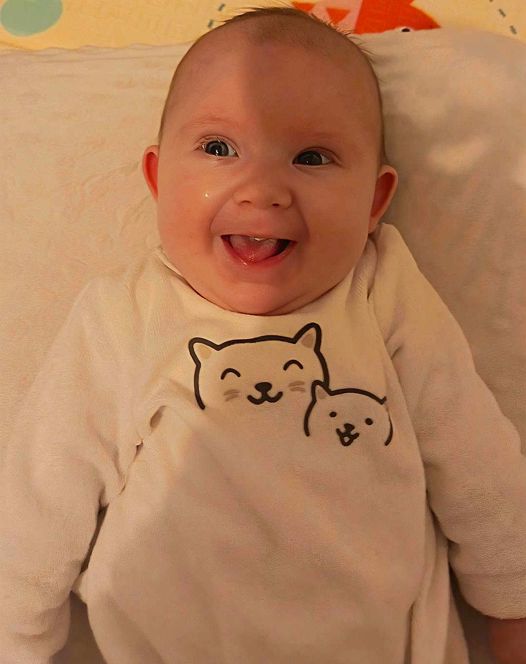 Luna participe au concours pour gagner de l'argent avec cette photo : baby, smiling, infant, cute, cozy, white_clothing, cartoon_cats, blanket, happy, portrait, indoors, child, soft_texture, young, face, tongue_out, warm_lighting, cute_outfit, closeup, playful