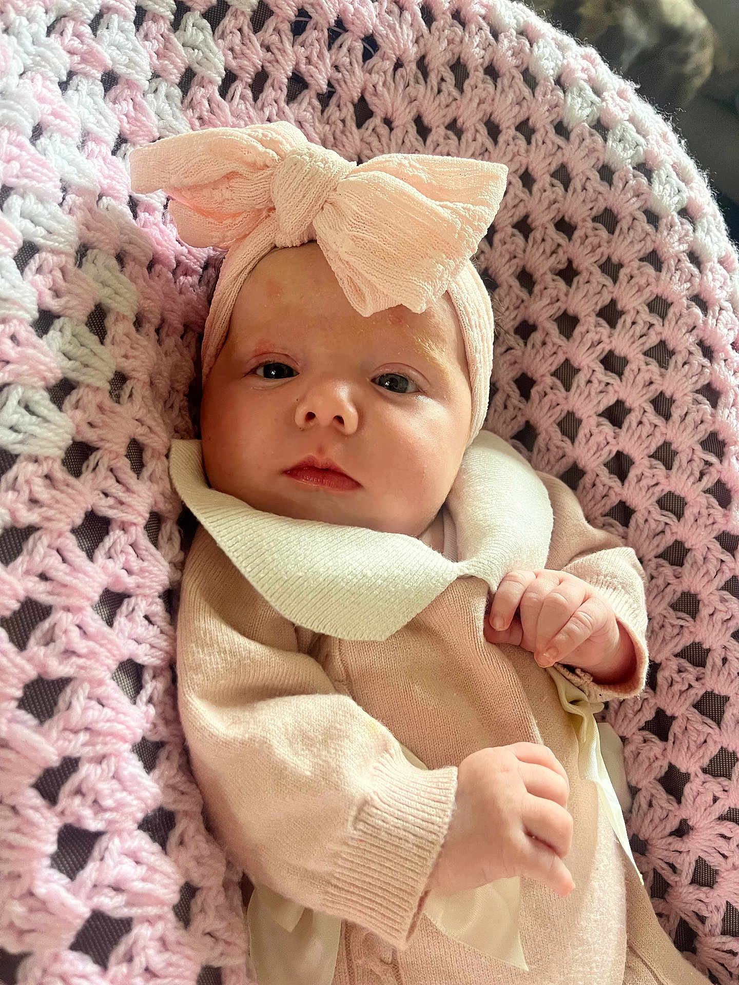 Naliah joined the competition — help win amazing prizes! baby, infant, headband, bow, pink, knitted_blanket, cozy, clothing, cute, portrait, newborn, soft_texture, hand, face, indoor, child, person, relaxed, closeup, sleepy