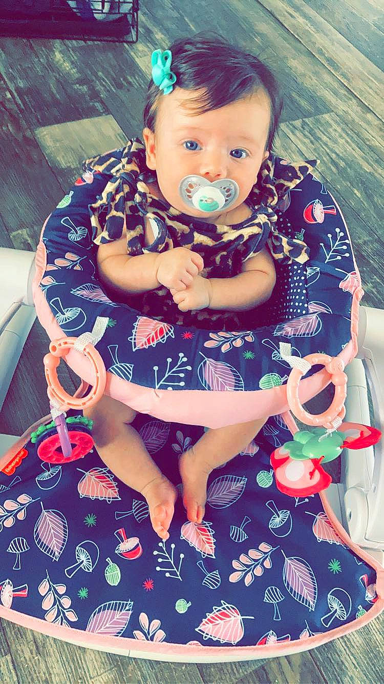 Jamie is registered to the contest to win money with this photo: baby_toddler_clothing, blue, cheek, cool, dress, face, fun, grass, hand, happy, head, iris, mouth, pattern, person, pink, purple, skin, sleeve, textile