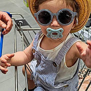 Luqmân a rejoint le concours — aidez-le/la à gagner de superbes lots ! accessories, baby, child, clothing, cute, fashion, floor, hand, hat, metal, pacifier, person, retail, shopping, shopping_cart, store, striped_overalls, sunglasses, supermarket, toddler