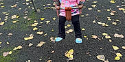 Bonnie is registered to the contest to win money with this photo: activity, autumn, black_pants, blue_shoes, chain, child, daytime, fun, girl, happy, jacket, leaves, outdoor, park, person, play, playground, slide, smile, swing