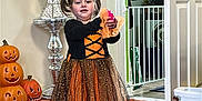 Bonnie joined the competition — help win amazing prizes! child, girl, halloween_costume, dress, indoor, carpet, pumpkin_decoration, toy, door, vase, flowers, baby_gates, socks, orange, black, white, home, floor, decor, playful