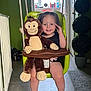 toddler, child, indoor, swing, plush_toy, monkey_toy, smile, happy, green_swing, window, floor, barefoot, toy, plant, decor, room, child_safety_seat, rope, radiator, casual_clothing