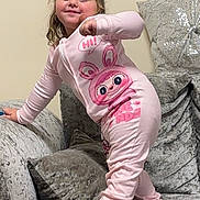Bonnie-Leigh is registered to the contest to win money with this photo: toddler, child, onesie, pink_clothing, antenna_headband, green_accessory, couch, plush_furniture, grey_pillows, indoor, smiling, posing, happy, cute, home, person, face, playful, cozy, soft_fabric