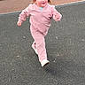 active, asphalt, casual_clothing, child, daylight, fun, happy, leisure, motion, outdoor, person, pigtails, pink_outfit, play, playground, recreation, running, smile, toddler, young_child