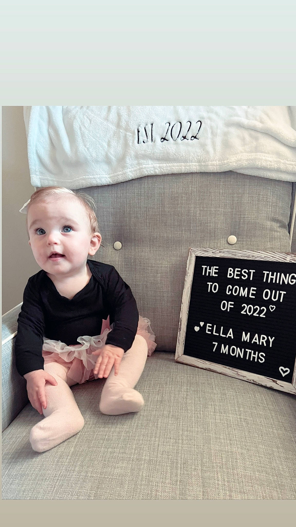 Ella is registered to the contest to win money with this photo: baby, baby_toddler_clothing, child, flash_photography, flooring, font, foot, grey, happy, hardwood, knee, pattern, person, picture_frame, rectangle, room, sitting, sleeve, t_shirt, toddler
