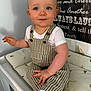 Harry joined the competition — help win amazing prizes! toddler, child, baby, blue_eyes, curly_hair, striped_overalls, white_tshirt, white_socks, changing_table, cushion, indoor, smiling, cute, portrait, person, furniture, signboard, text_background, cozy, home