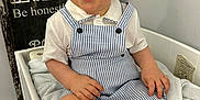 Harry is registered to the contest to win money with this photo: toddler, child, blue_eyes, curly_hair, striped_clothing, romper, white_shirt, towel, indoor, smiling, sitting, furniture, signboard, wood, homedecor, cute, baby, skin, face, happy