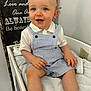 toddler, child, blue_eyes, curly_hair, striped_clothing, romper, white_shirt, towel, indoor, smiling, sitting, furniture, signboard, wood, homedecor, cute, baby, skin, face, happy