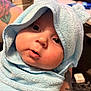 baby, child, towel, blue_towel, hooded_towel, face, eyes, lips, skin, tattoo, arm, indoor, portrait, cute, closeup, expression, infant, person, soft_texture, newborn