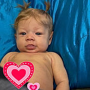 Ava is registered to the contest to win money with this photo: baby, blue_blanket, child, curious, cute, expression, face, head, heart_stickers, indoors, infant, lying_down, modesty_cover, person, pigtails, portrait, skin, tongue, upper_body, young_child