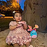 Layla joined the competition — help win amazing prizes! baby, child, toddler, portrait, outdoor, night, streetlight, pink_dress, bow, hair_accessory, smiling, sitting, plush_toy, stuffed_animal, flowers, shoes, sidewalk, stone_wall, trees, car