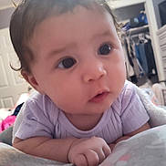 Monica joined the competition — help win amazing prizes! baby, infant, child, face, eyes, close_up, portrait, indoors, onesie, clothing, blanket, bed, tummy_time, adorable, chubby_cheeks, expression, hair, closet, room, soft_light