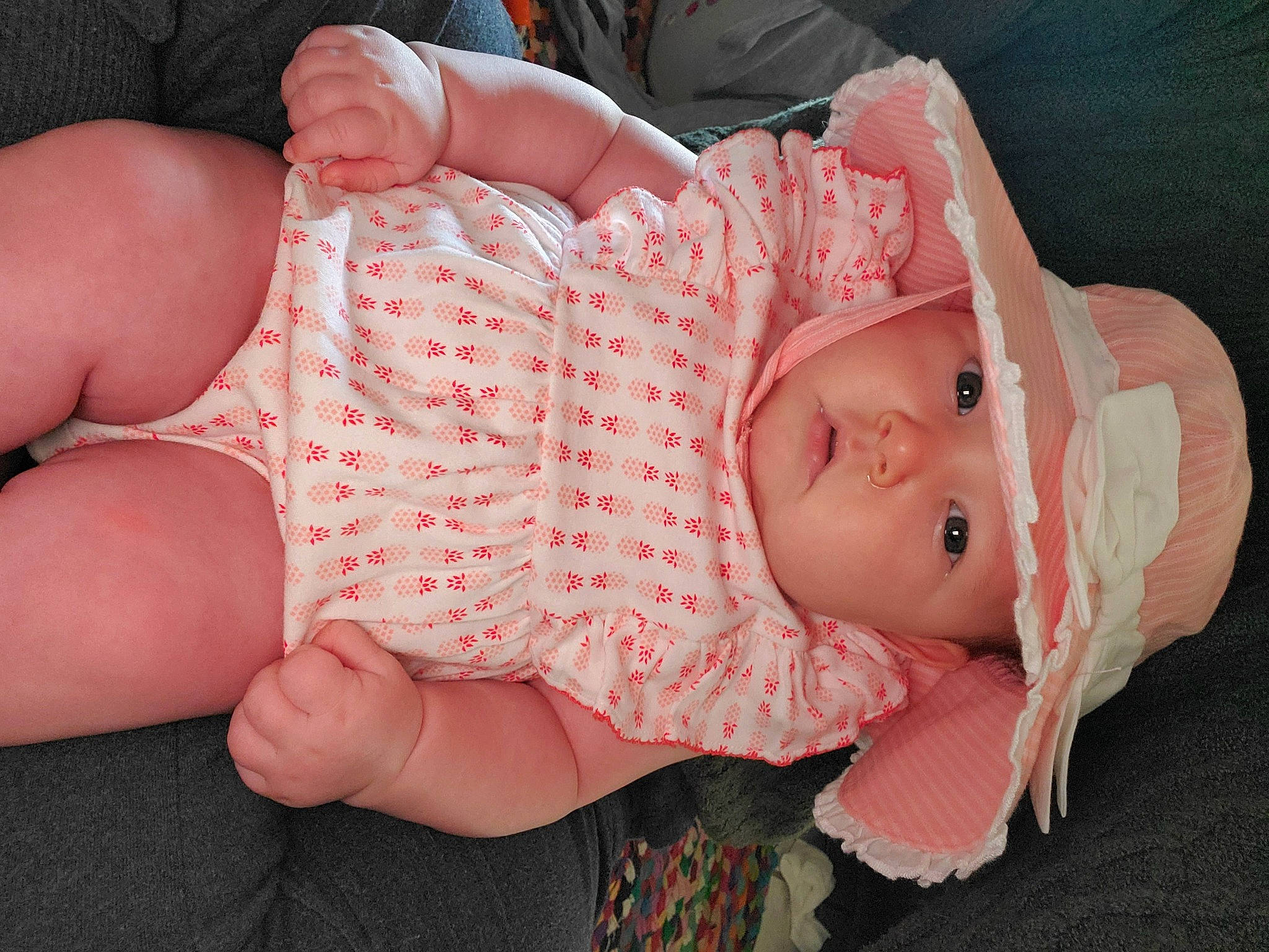 Rowan is registered to the contest to win money with this photo: baby, baby_toddler_clothing, chest, dress, eye, face, finger, glasses, hand, hat, headwear, human_body, lip, mouth, neck, person, pink, skin, thigh, thumb