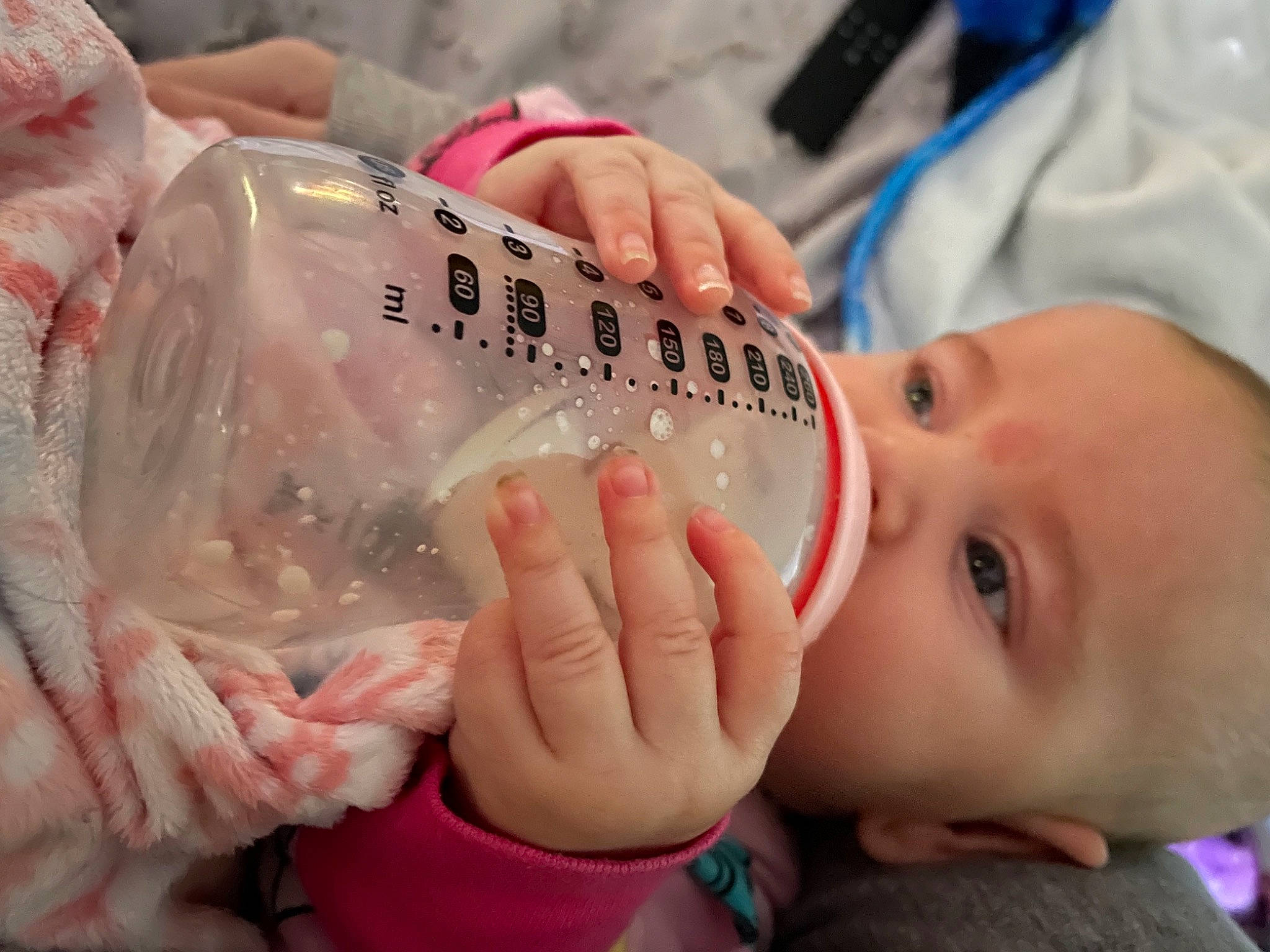 Emberly is registered to the contest to win money with this photo: baby, baby_bottle, baby_toddler_clothing, bottle, cheek, child, drink, drinkware, eyelash, finger, fluid, gesture, hand, infant_formula, mouth, nail, person, plastic_bottle, skin, thumb