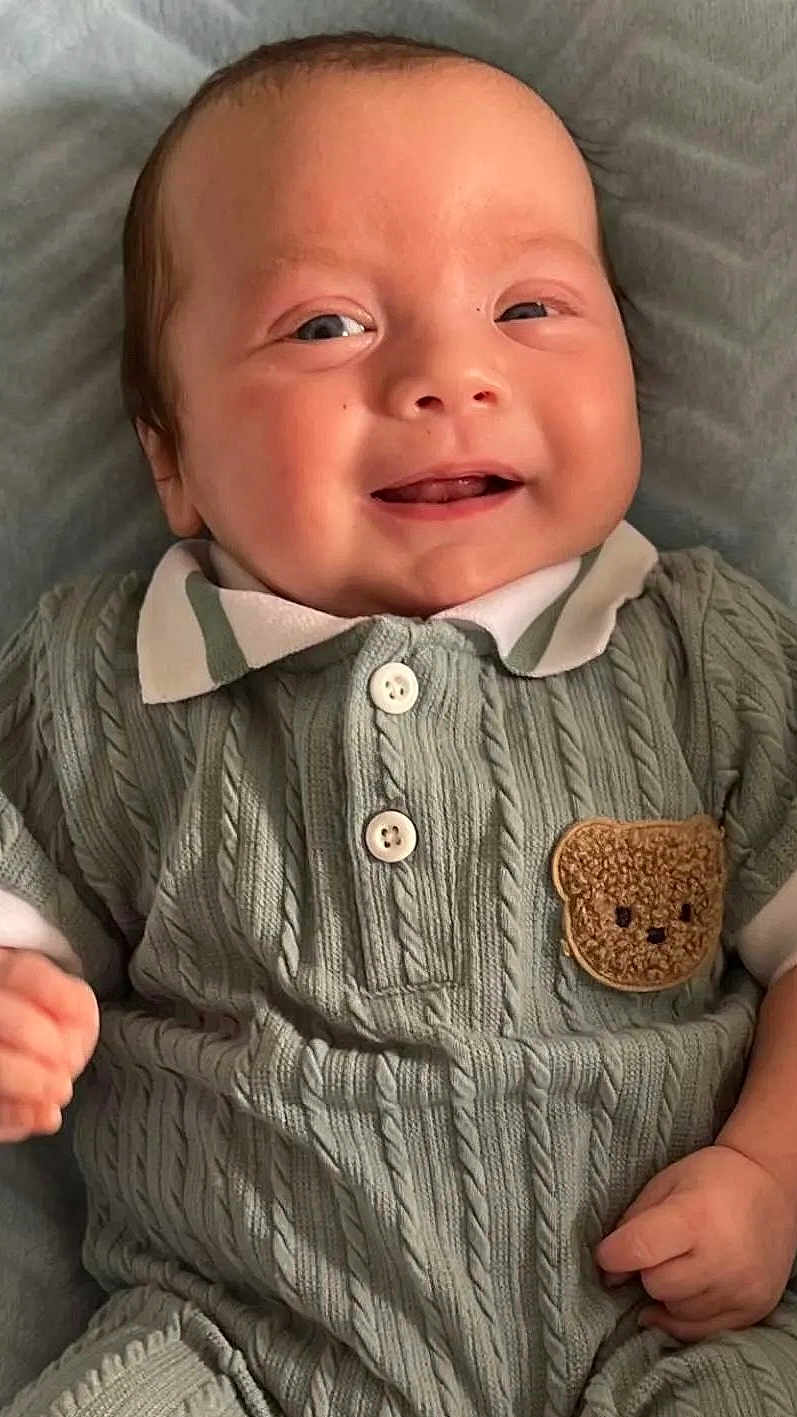 Harrison is registered to the contest to win money with this photo: baby, smiling, infant, knitted_clothing, teddy_bear_patch, cute, happy, portrait, child, cozy, buttoned_shirt, texture, soft_blanket, closeup, young_child, face, hand, casual, indoors, cute_expression