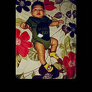 Liam is registered to the contest to win money with this photo: adorable, baby, baby_boy, child, colorful, cute, floral_bedspread, happy, indoors, infant, lying_down, onesie, patterned, person, portrait, resting, sleepwear, smiling, socks, young_child