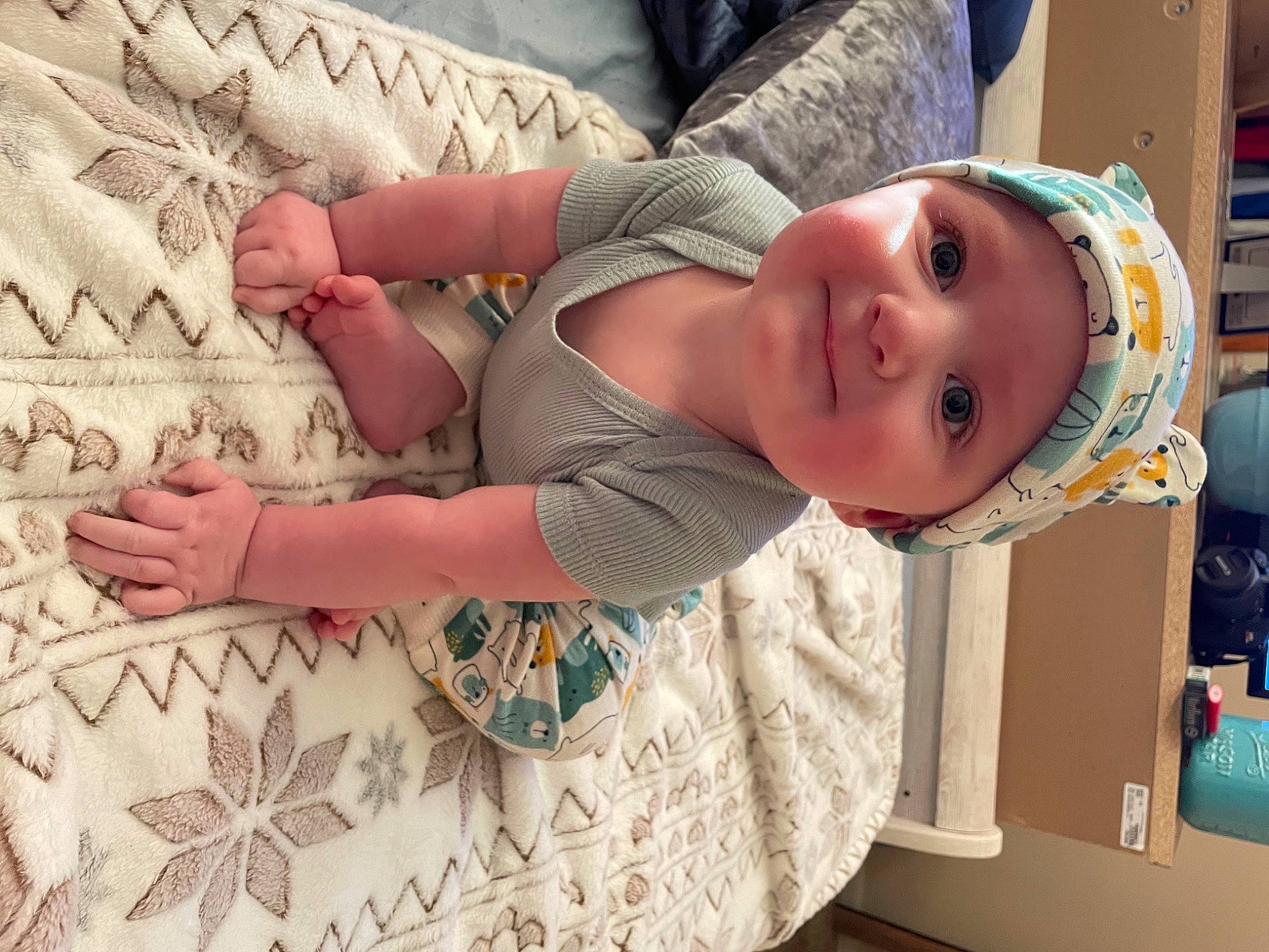 Asher is registered to the contest to win money with this photo: baby, baby_toddler_clothing, child, eye, face, finger, flooring, fun, gesture, happy, headwear, human_body, joy, linens, pattern, person, skin, sleeve, smile, t_shirt