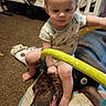 Estella is registered to the contest to win money with this photo: baby, dog, child, play_mat, toy, carpet, crib, indoor, infant, pet, smiling_dog, crawling, clothing, foot, hand, face, playtime, home, yellow_toy, bonding