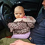 baby, child, infant, car, steering_wheel, leopard_print, jacket, adult, man, lap, seat, window, door, clothing, hand, face, blue_eyes, outdoor, vehicle, casual
