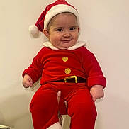 Natalya a rejoint le concours — aidez-le/la à gagner de superbes lots ! baby, child, santa_hat, red_clothing, holiday_outfit, smiling, cute, festive, indoor, person, portrait, hands, white_background, chubby_cheeks, christmas, holiday, infant, red_pants, red_sleeves, white_fur_trim
