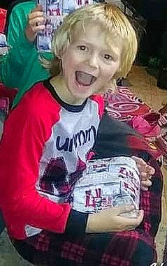 Dominick is registered to the contest to win money with this photo: blond, child, cool, event, fun, hair, hairstyle, happy, jersey, laugh, magenta, mouth, pattern, person, photo_caption, sitting, sleeve, smile, sportswear, t_shirt