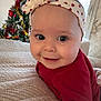 baby, child, smiling, headband, red_clothing, christmas_tree, holiday_decorations, knitted_blanket, indoor, cute, portrait, festive, happy, infant, closeup, face, eyes, cozy, seasonal, warm