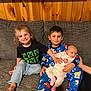 child, baby, pajamas, couch, smile, barefoot, indoor, wood_paneling, family, sibling, holding, happy, clothing, cute, relaxed, portrait, person, infant, casual, seated