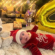Milya a rejoint le concours — aidez-le/la à gagner de superbes lots ! baby, christmas_tree, holiday, presents, ornaments, lights, santa_hat, red_clothing, fluffy_rug, toy, gold_balloon, nutcracker, festive, celebration, indoors, decorations, smiling, cute, winter, holiday_season