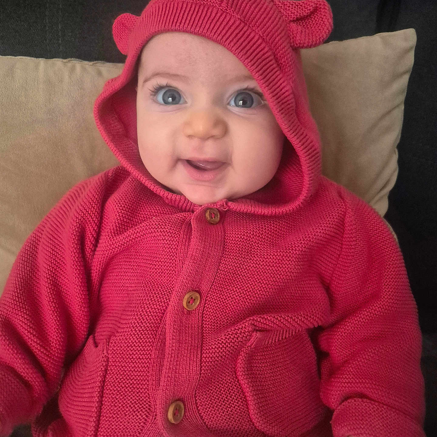 évélina participe au concours pour gagner de l'argent avec cette photo : baby, big_eyes, button, child, couch, cozy, cute, eyelashes, fabric, hand, hoodie, indoor, infant, knitwear, pillow, pocket, portrait, red_hoodie, sitting, smile