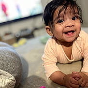 Chaïna a rejoint le concours — aidez-le/la à gagner de superbes lots ! baby, child, smiling, happy, tummy, hands, clasped_hands, face, eyes, hair, indoor, crawling, cute, infant, person, skin, clothing, blurred_background, closeup, portrait