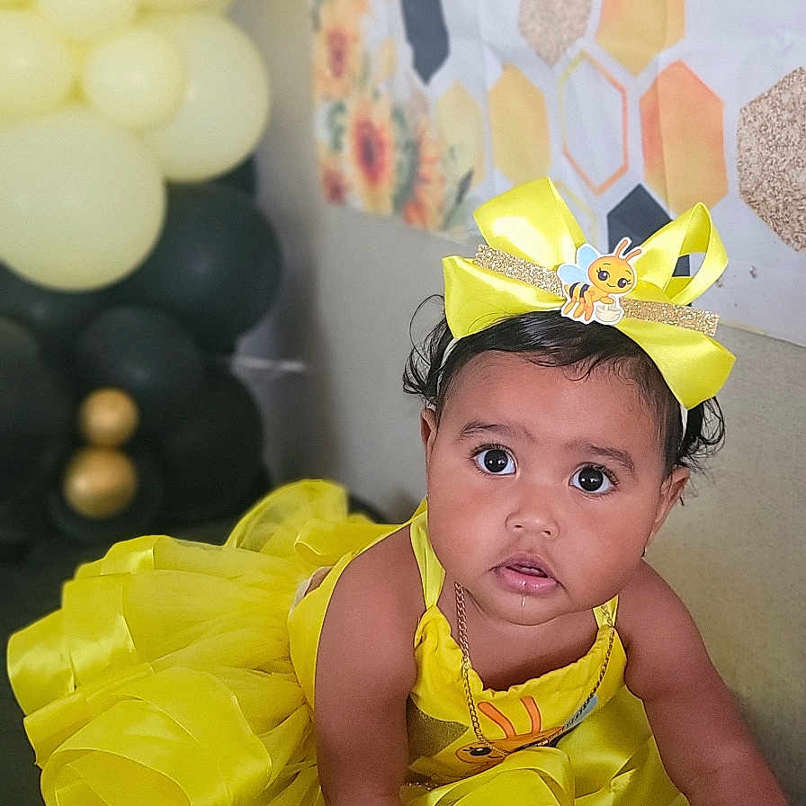 Jaseirys joined the competition — help win amazing prizes! baby, balloons, bee_theme, black_surface, bow, celebration, child, closeup, crawling, curious, cute, festive, headband, honeycomb_pattern, indoors, infant, party_decorations, portrait, sunflower, yellow_dress