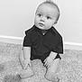 baby, infant, child, sitting, carpet, portrait, black_and_white, monochrome, shirt, short_sleeve, bare_feet, big_eyes, hair_spike, wall, baseboard, floor, indoor, cute, face, hands