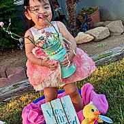 Katalayiah joined the competition — help win amazing prizes! toddler, child, pink_dress, flower_vase, outdoor, grass, toy_duck, sign, happy, smiling, garden, plants, sunlight, decor, playtime, cute, portrait, nature, young_child, holding_object