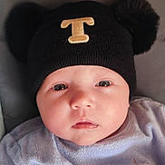 Taëlyna a rejoint le concours — aidez-le/la à gagner de superbes lots ! baby, infant, face, hat, black_hat, pom_poms, clothing, portrait, close_up, cute, child, skin, eyes, mouth, expression, headwear, soft_texture, indoors, young, person