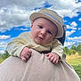 Simon a rejoint le concours — aidez-le/la à gagner de superbes lots ! adult, baby, child, clothing, clouds, cute, daylight, expression, face, grass, greenery, hands, hat, headwear, nature, outdoor, person, portrait, shoulder, sky
