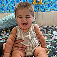 Esteban Muñoz joined the competition — help win amazing prizes! baby, child, smiling, sitting, striped_onesie, hand, bedspread, pillow, plush_toy, sesame_street, cookie_monster, elmo, oscar_the_grouch, colorful, indoor, portrait, happy, cute, infant, fun