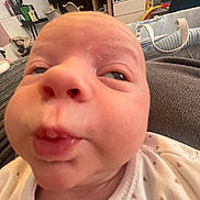 Joshua joined the competition — help win amazing prizes! baby, closeup, face, infant, expression, indoor, person, newborn, clothing, cute, skin, mouth, eyes, head, nose, home, furniture, blanket, baby_bed, pout