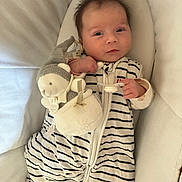 Rosyanna participe au concours pour gagner de l'argent avec cette photo : baby, infant, sleeping_sack, plush_toy, soft_toy, striped_clothing, cushion, cozy, child, cute, indoors, resting, comfort, face, person, small_child, baby_garment, smile, toy, lying_down