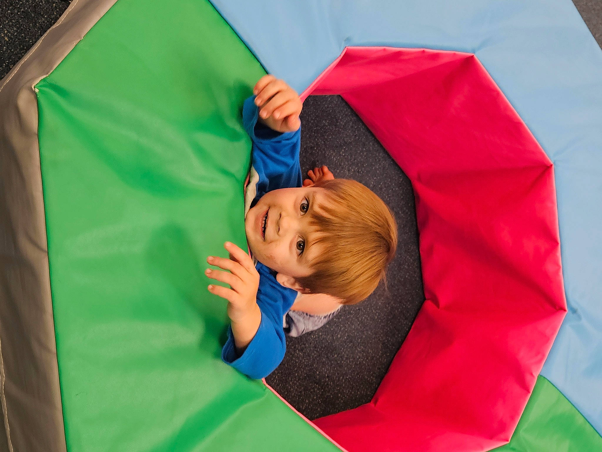 Jason is registered to the contest to win money with this photo: baby, child, comfort, electric_blue, fun, grass, happy, joy, leisure, linens, magenta, organism, person, play, recreation, room, sitting, sleeve, tarpaulin, toddler