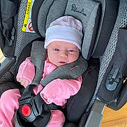 Imogen joined the competition — help win amazing prizes! baby, infant, car_seat, pink_clothing, hat, safety_harness, face, person, child, newborn, seat, fabric, indoor, cute, small, headwear, resting, comfort, protection, baby_gear