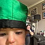 Riley joined the competition — help win amazing prizes! toddler, child, green_cap, face, indoor, living_room, adult, sofa, lamp, photography, blurred_background, portrait, person, home, casual, close_up, expression, hat, candid, furniture