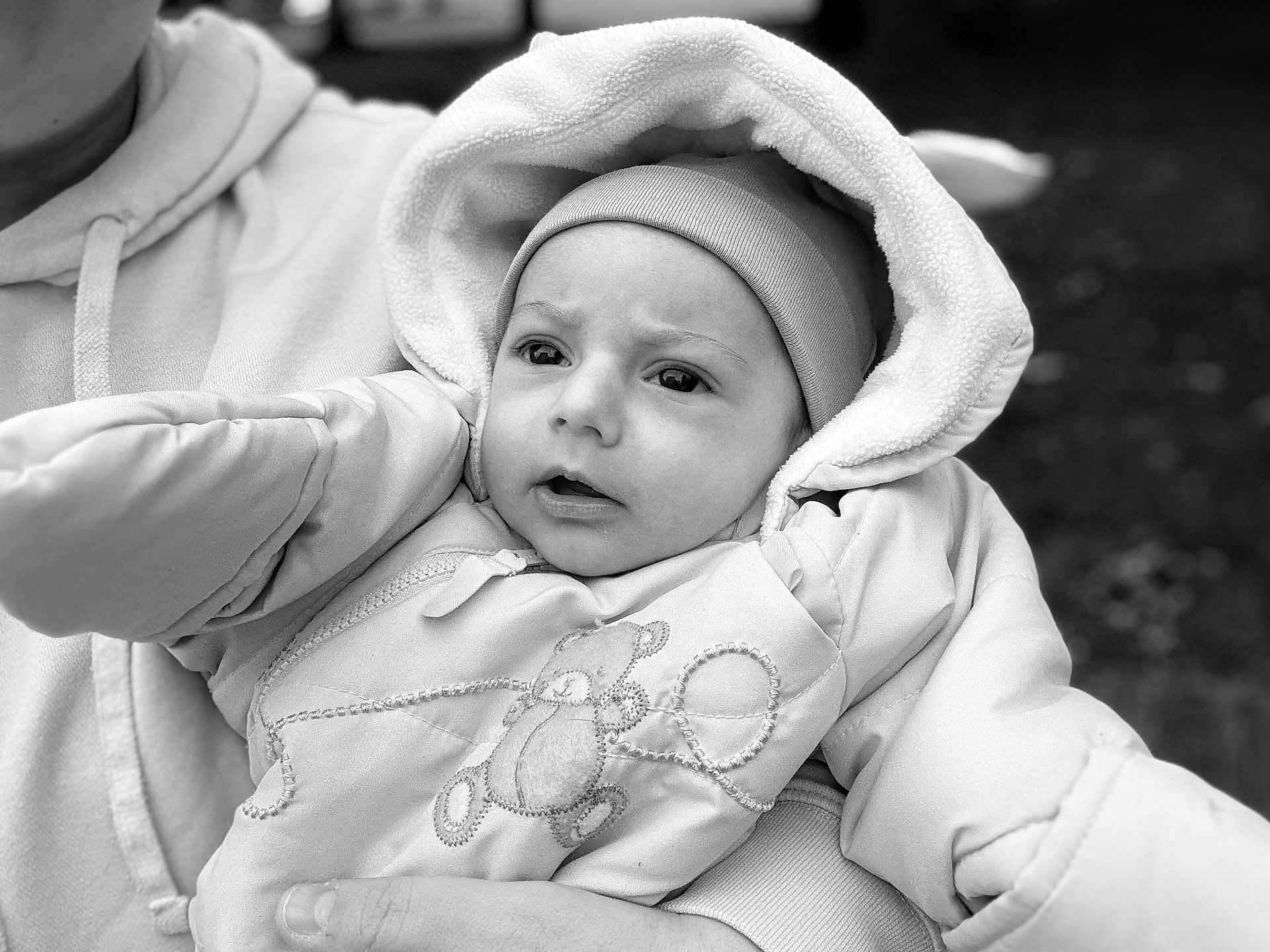 Enzo Rafael participe au concours pour gagner de l'argent avec cette photo : baby, child, face, hood, jacket, hand, person, portrait, cute, warm_clothing, outdoor, black_and_white, teddy_bear, holding, expression, hoodie, newborn, infant, closeup, winter