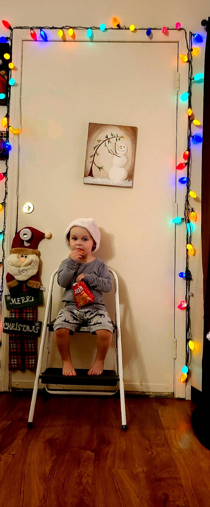 Briar is registered to the contest to win money with this photo: art, artist, baby, child, collection, eyewear, flooring, fun, hat, headwear, knee, person, picture_frame, room, shorts, sitting, t_shirt, toddler, vacation, visual_arts