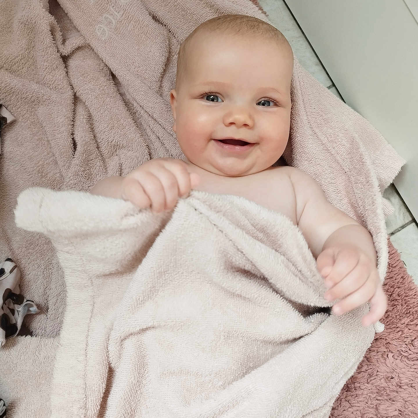 Mya participe au concours pour gagner de l'argent avec cette photo : baby, babycare, blanket, child, cozy, cute, eyes, face, floor, hand, happy, head, indoor, infant, person, portrait, skin, smile, soft, towel