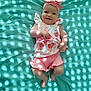 Mya participe au concours pour gagner de l'argent avec cette photo : baby, infant, smiling, headband, pink_clothing, floral_pattern, lying_down, teal_background, sunlight_pattern, cute, child, happy, portrait, indoors, soft_light, small_feet, chubby_arms, fashion, playful, adorable