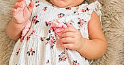 Rylee is registered to the contest to win money with this photo: baby, smiling, headband, bow, floral_dress, infant, happy, hands, clapping, lying_down, rug, soft_texture, cute, cheerful, child, portrait, indoors, skin, face, expression