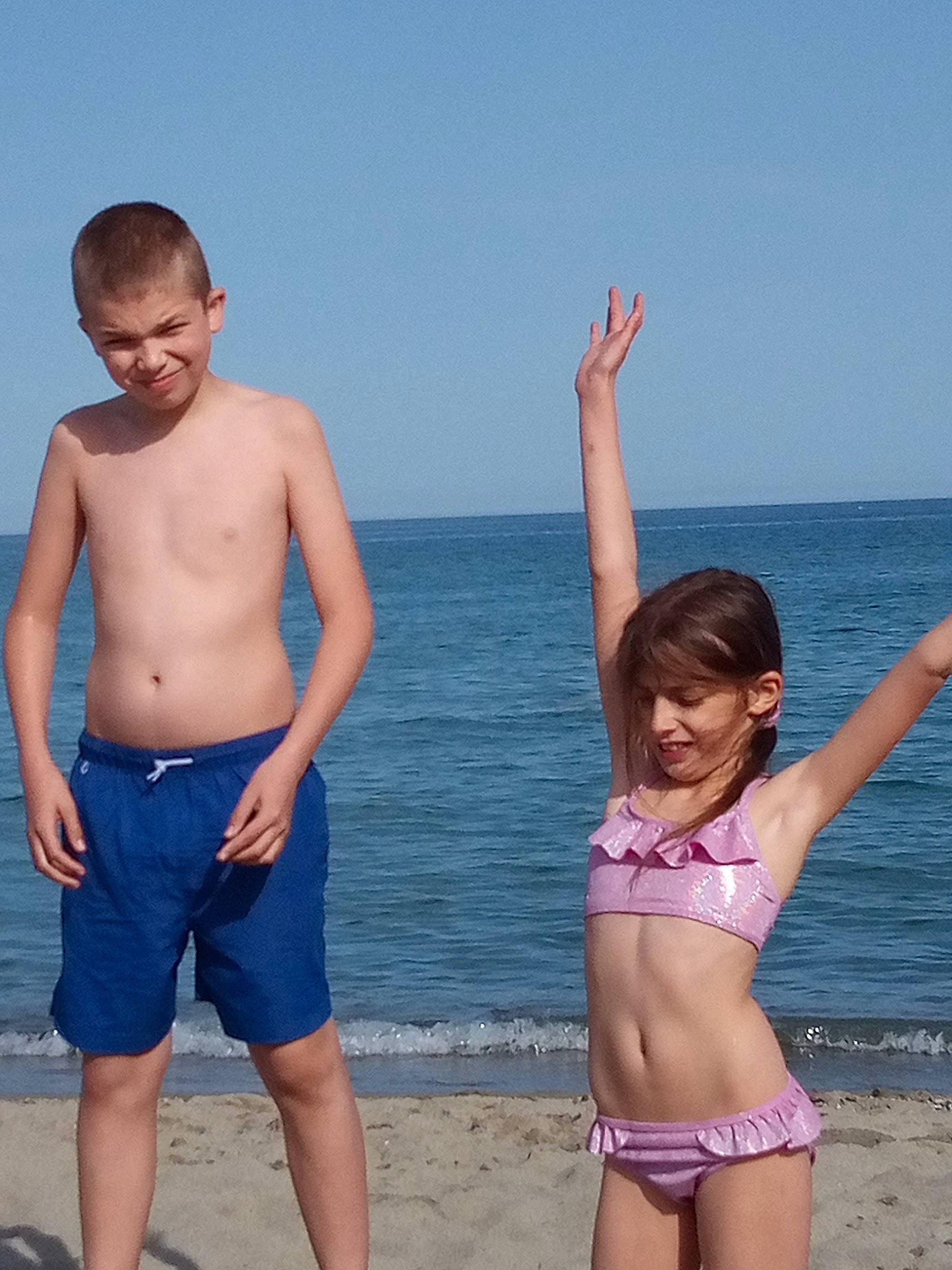 Enzo a rejoint le concours — aidez-le/la à gagner de superbes lots ! azure, beach, chest, gesture, happy, human_body, joy, leisure, lingerie_top, natural_environment, people_in_nature, people_on_beach, person, shorts, sky, standing, swimsuit_top, swimwear, thigh, trunks