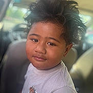 Jj is registered to the contest to win money with this photo: child, boy, tshirt, bear_graphic, hair, messy_hair, car_interior, seat, portrait, face, smile, casual_clothing, young, indoors, window, seatbelt, person, cute, expression, relaxed