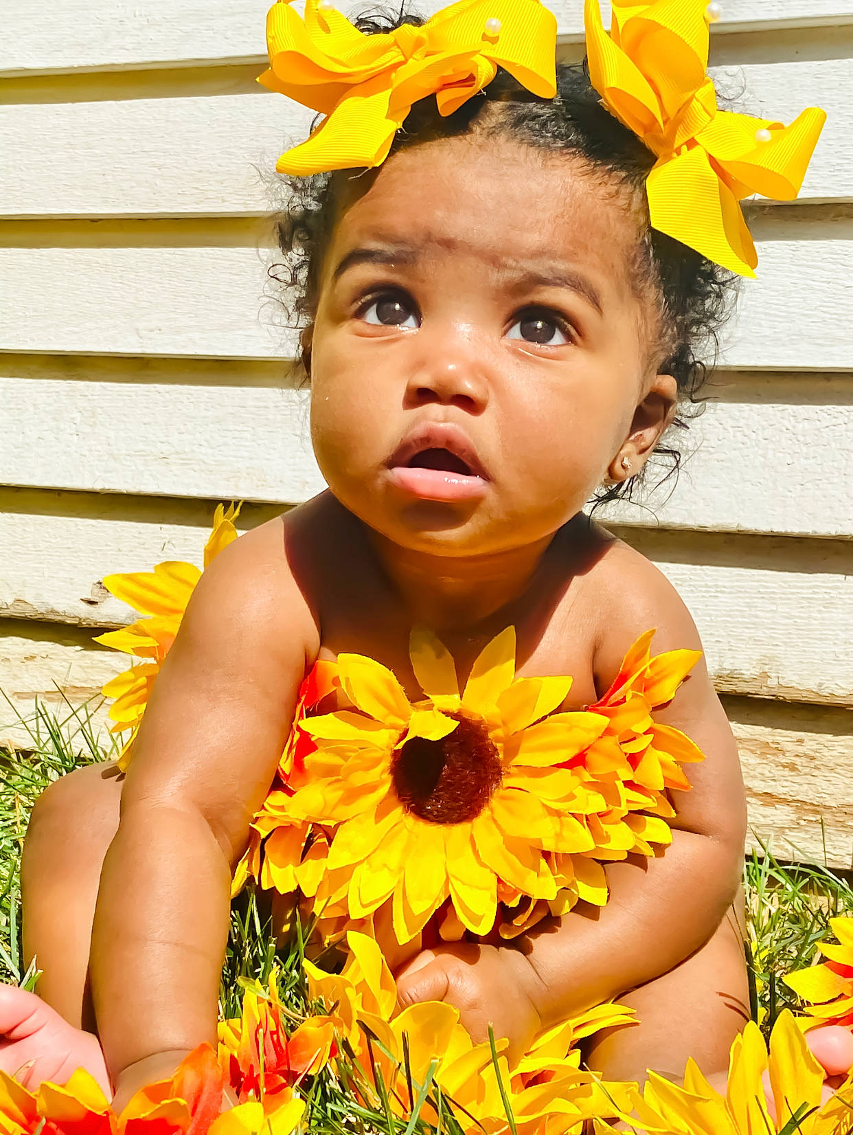 Janiya is registered to the contest to win money with this photo: beauty, costume_hat, eye, flower, flower_arranging, grass, happy, hat, head, human_body, iris, leaf, orange, organ, people_in_nature, person, petal, plant, surprise, toddler